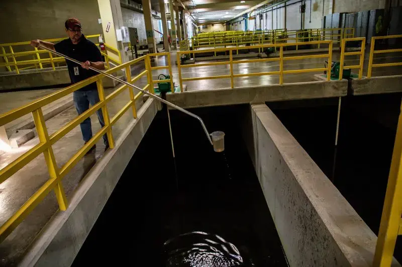 Assistant plant manager Brian Thompson takes a water sample from a section of the Morgan Water Treatment Plant in Cleveland on Sept. 26, 2019. Image by Zbigniew Bzdak. United States, 2019.