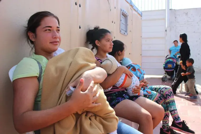 Venezuelan mothers wait to vaccinate their babies at a humanitarian clinic in La Parada, Cucuta, Colombia. Many new mothers regularly make the journey to Colombia to seek medical treatment. Image by Mariana Rivas. Colombia, 2019.