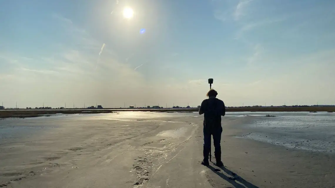 A scientist from the Army Corps of Engineers measures the elevation of newly placed dredge material on Gull Island, located within the Intracoastal Waterway off Stone Harbor in Cape May County. Image courtesy of the Wetlands Institute.
