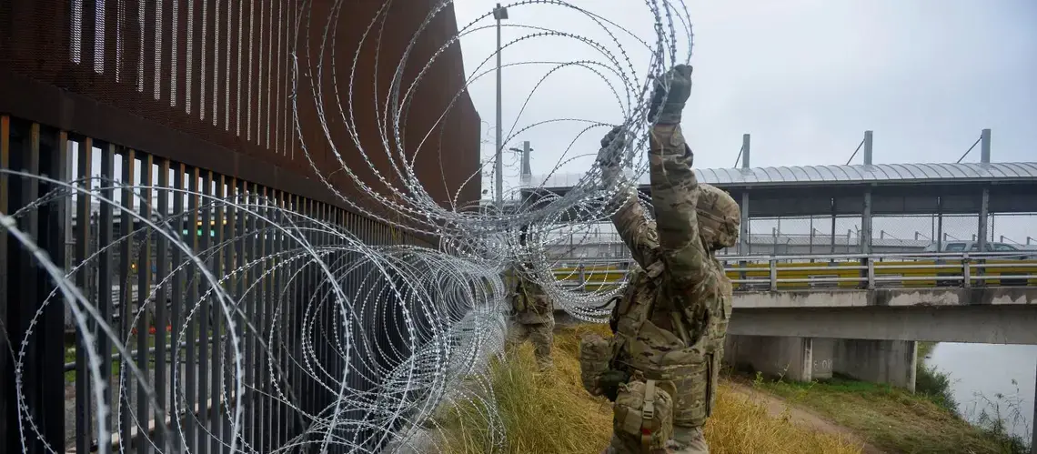 U.S. Army soldiers with the 889th Engineering Support Company, lay concertina wire along the Gateway International Bridge in Brownsville. Image courtesy of U.S. Air Force, via Reuters. United States, 2018.