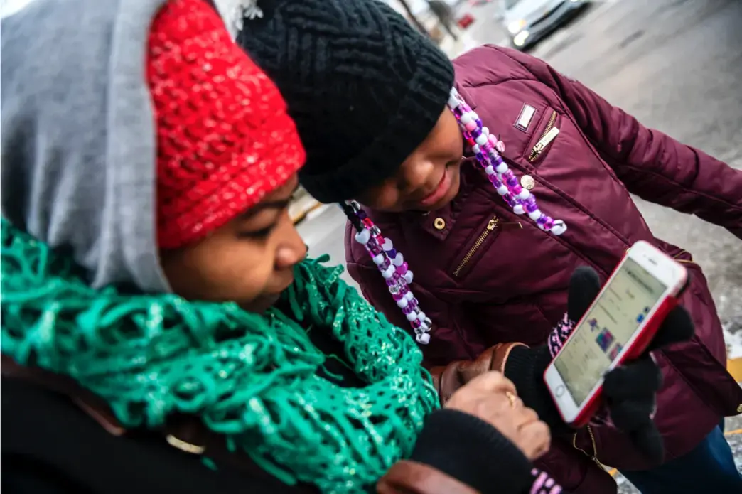 Nicole Glaze owner of Great Start Day Care in North Braddock, left, and Kee’Miyah West, 8, look at Kee'Miyah's Christmas toy wishlist. Image by Michael M. Santiago/Post-Gazette. United States, 2019.