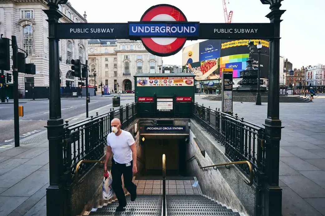 A person wearing a mask exits the London underground. Photo by Matteo Roma / Shutterstock. United Kingdom, 2020.