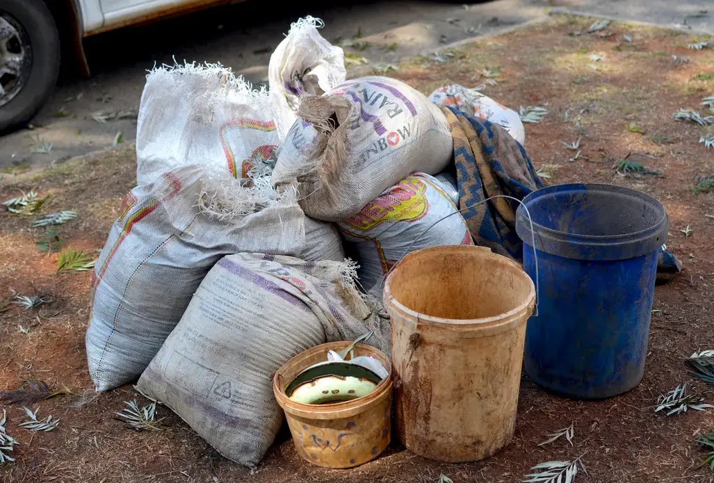 Bags of gold ore are confiscated from zama zamas at the abandoned Blyvooruitzicht Gold Mine. Image by Mark Olalde. South Africa, 2017.
