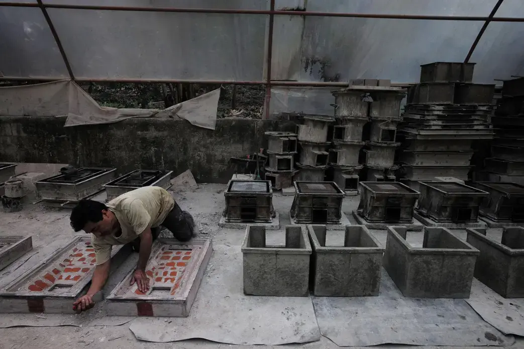 The Ecocomal factory outside of Antigua makes concrete stoves that vent smoke outdoors through a pipe and also burn wood far more efficiently than does an open fire—protecting human health and trees at the same time. Many of the stoves are sold to aid groups for distribution to poor families. Image by Lynn Johnson. Guatemala, 2017.