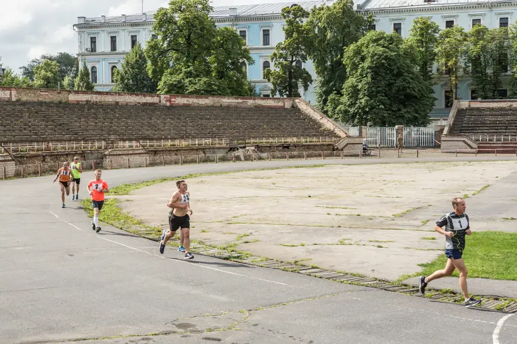 Oleksandr Popruzhenko (yellow) runs with teammate Oleksandr Radioniuk (blue) in the qualifying race for the marathon. Image by Oksana Parafeniuk, courtesy of Roads & Kingdoms. Ukraine, 2018.