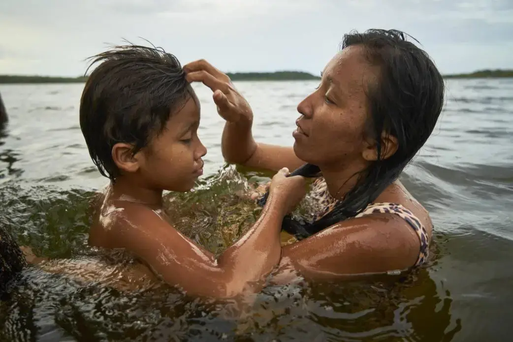 Tupí se da un baño con su hijo de 10 años. Foto por Pablo Albarenga. Brasil, 2019.