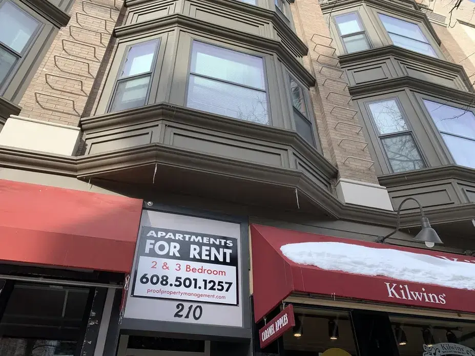 A sign advertises apartments to rent above a business in Madison, Wisconsin.