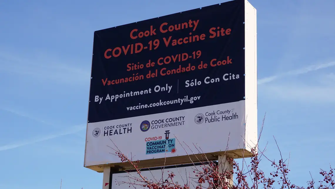 A sign for a Cook County COVID-19 mass vaccination site in suburban Chicago. The sign is bilingual in English and Spanish.