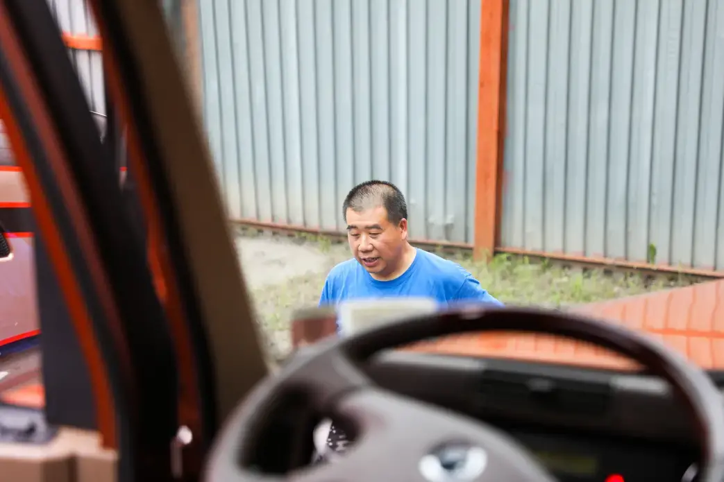 A view of Tom Tang through the dashboard of a truck.