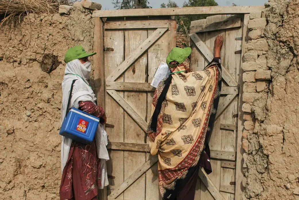 A female polio worker marks a house as visited after vaccinating children at a Christian colony in Lahore, Pakistan.