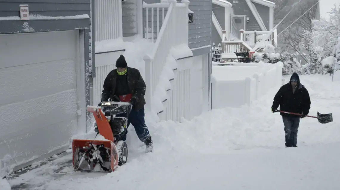 two people plowing snow