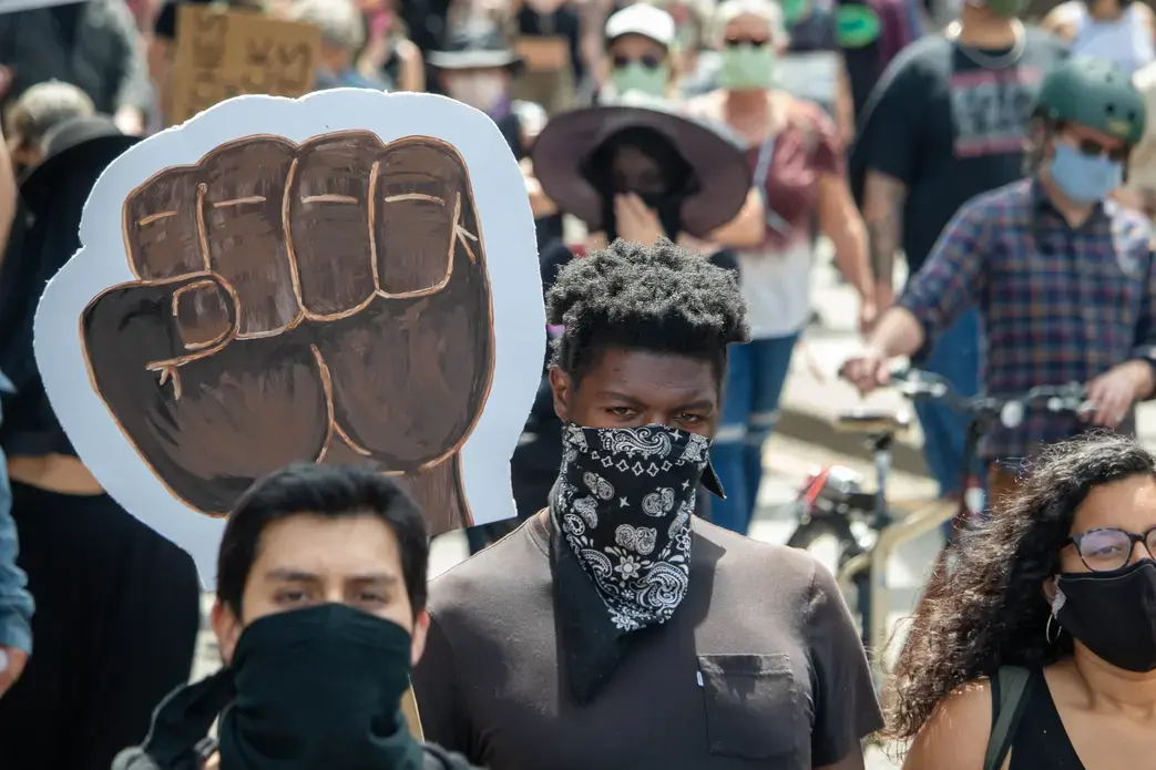 Individuals march in direction of photographer.
