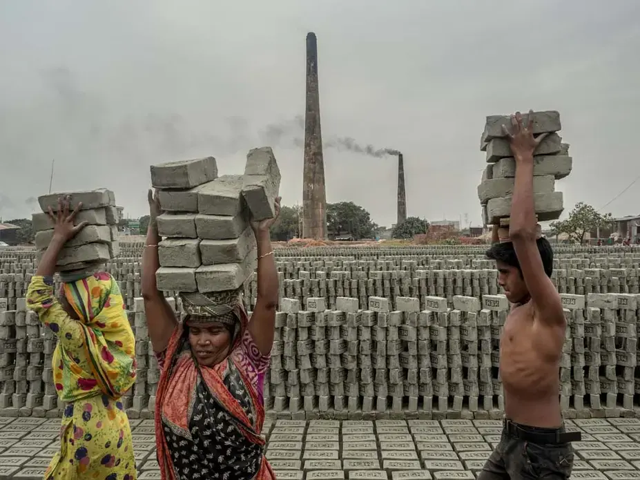 Workers carry bricks after they are formed and stack them in preparation for firing. Roughly one million people are employed in Bangladesh’s brickmaking facilities, which generate nearly 60 percent of the particulate pollution in Dhaka. Image by Larry C. Price. Bangladesh, 2018.