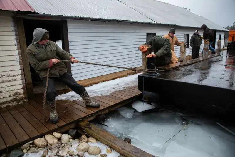 Dock builders from North Shore Docks secure a barge at Patrick's Landing at Les Cheneaux Islands in the Upper Peninsula of Michigan on Nov. 20, 2019. Image by Zbigniew Bzdak / Chicago Tribune. United States, 2020.