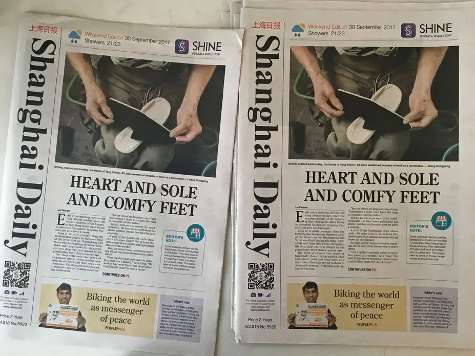 Copies of the Shanghai Daily set out on a table in the Daily's newsroom on Sunday, Sept. 30, 2017, in Shanghai. Image by Kelsey Kremer. China, 2017.