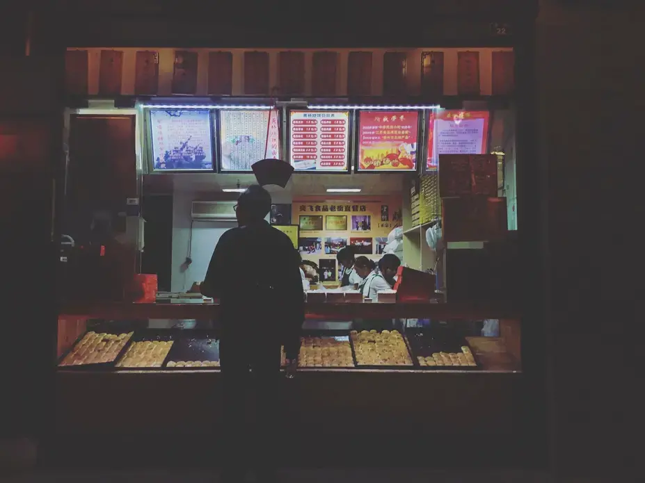 Michael Lee, owner of the Hamburg Inn in Iowa City, purchases baked goods from a street vendor on Thursday, Sept. 28, 2017, in Taizhou. Image by Kelsey Kremer. China, 2017.