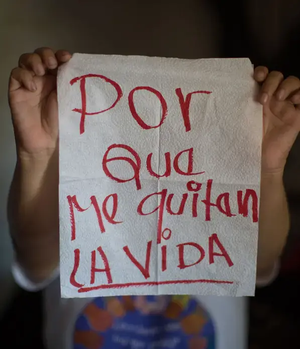 Clabriel, 30+.</p>
<p>The napkin reads: 'because of feat of being murdered'. Beginning when she was 8, she was the victim of sexual abuse at the hands of her stepfather. As an adult, she battled for years with breast cancer, which almost killed her. Then, she was harassed by the gangs, who murdered her husband.</p>
<p>Image by Almudena Toral. El Salvador, 2018.