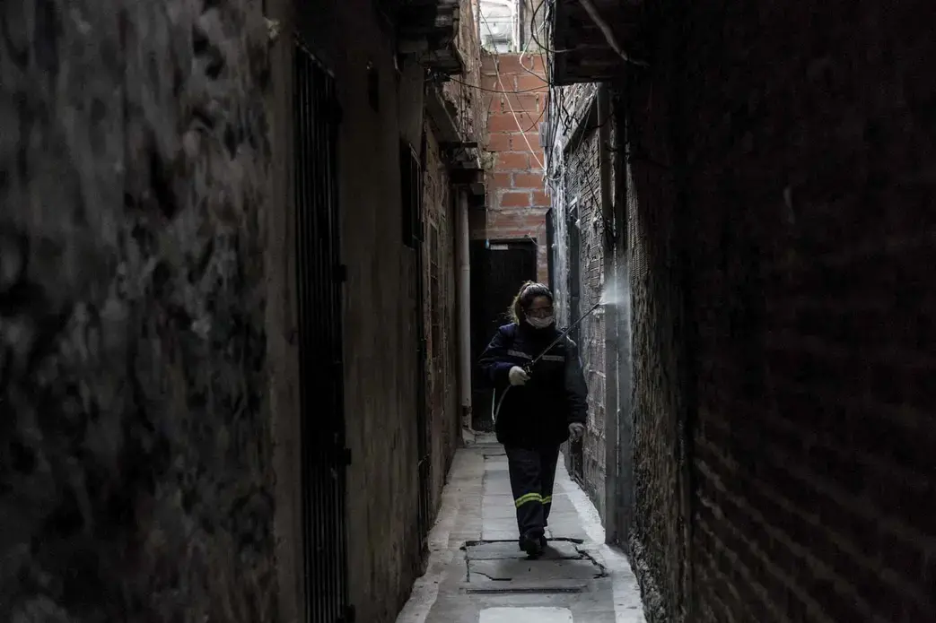 A member of the cleaning cooperative disinfecting the narrow alleys of the slum. Image by Anita Pouchard Serra. Argentina, 2020.