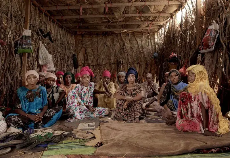 Ethiopian migrant girls sit inside in a smugglers' lockup, known in Arabic as a 'hosh,' in Ras  al-Ara, Lahj Yemen, July 25, 2019. Some lockups hold as many as 50 women at a time. The women stay here for several days until their transportation is ready. Image by AP Photo / Nariman El-Mofty. Yemen, 2019.