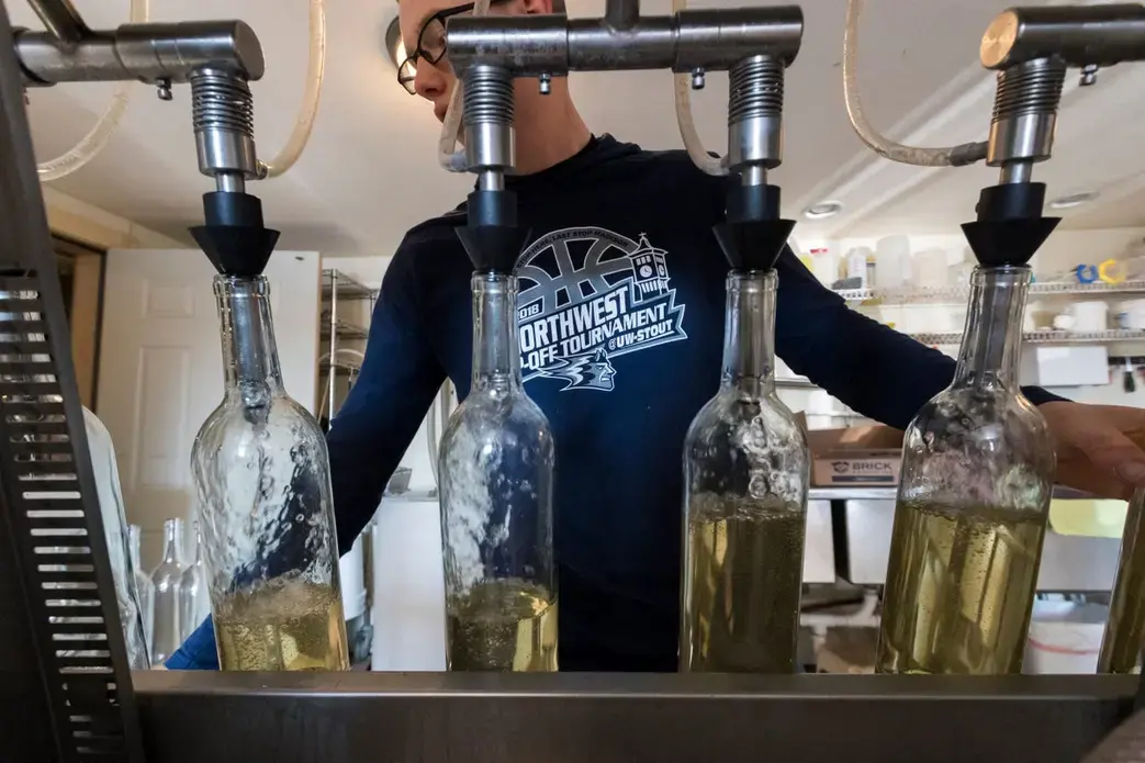 Issac Mathison bottles wine at Munson Bridge Winery in Withee. Image by Mark Hoffman. United States, 2019.