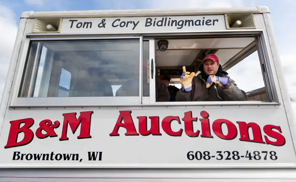 Cory Bidlingmaier solicits bidders interested in hay during an auction. Image by Mark Hoffman. United States, 2019.