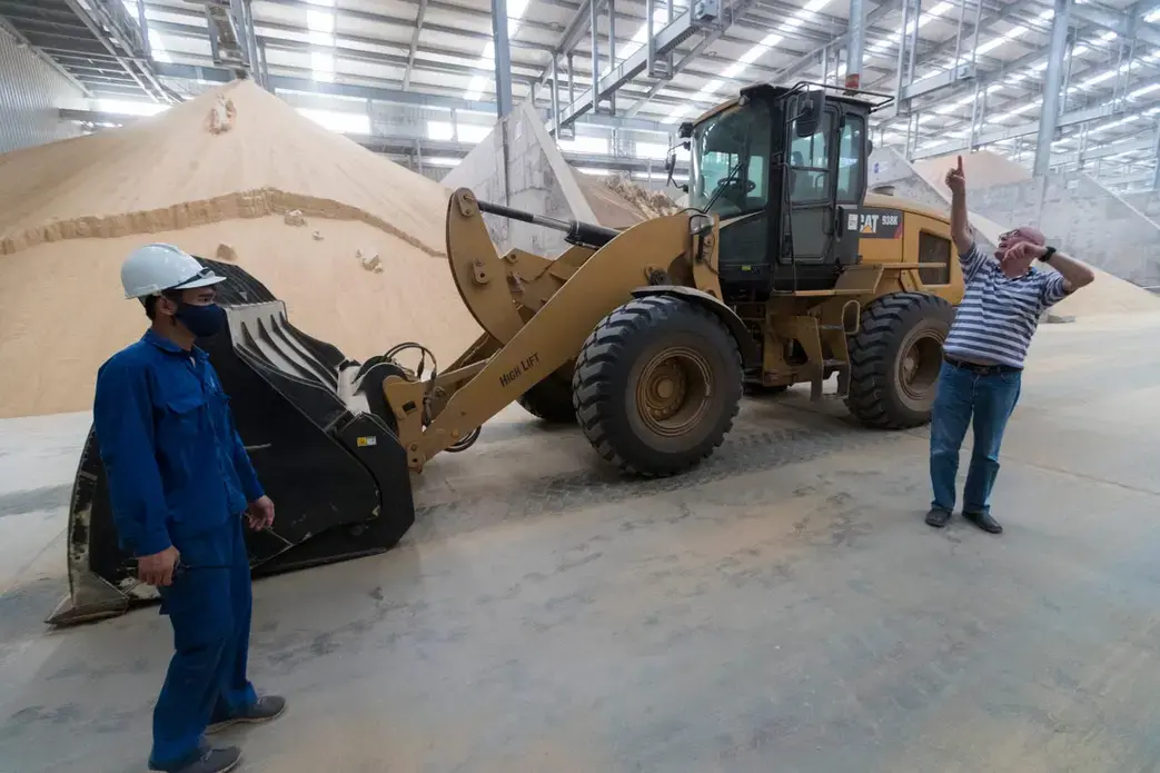 Hanan Saggi, right, feed and nutrition general manager at TH Milk's operations in Nghia Son, Vietnam, makes a point in the nutritional supplements warehouse. The Israeli-born dairy expert has been with the company since its inception a decade ago. Image by Mark Hoffman. Vietnam, 2019. 