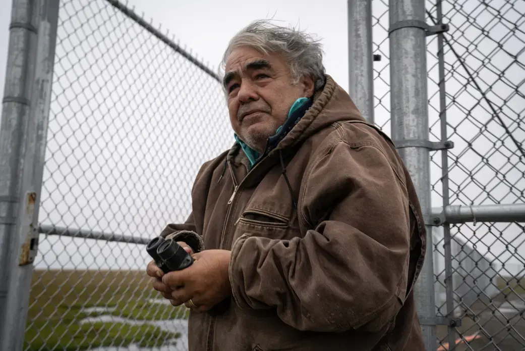 Robert Thompson, Kaktovik polar bear guide, holding his binoculars. Image by Nick Mott. United States, 2019.