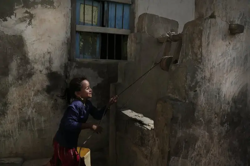 In this Feb. 12, 2018, photo, a girl pulls water from a well in the home of Ahmed al-Kawkabani, leader of the southern resistance unit in Hodeida, in al-Khoukha, Yemen. Image by Nariman El-Mofty. Yemen, 2018. </p>
<p>