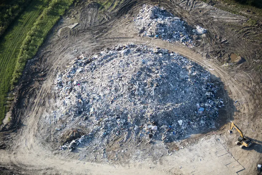 At a temporary dump north of Beaumont, containing nearly a hundred thousand cubic yards of furniture and demolition waste from the suburbs of Bevil Oaks and Northwest Forst, crushed water-damaged drywall gleams white. Image by Alex MacLean. United States, 2017.