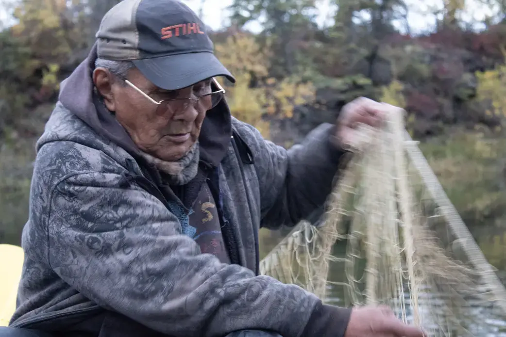 Gideon James checking his fishing net. Image by Amy Martin. United States, 2019.