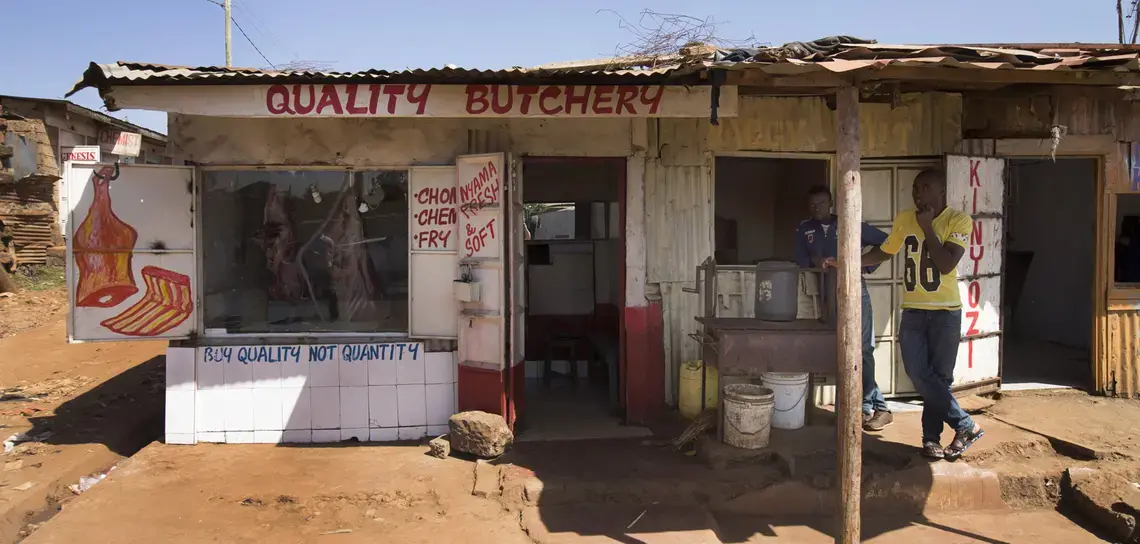 Beef carcasses hang in a butcher shop in the Kawangware slum. Image by Mark Hoffman. Kenya, 2017.