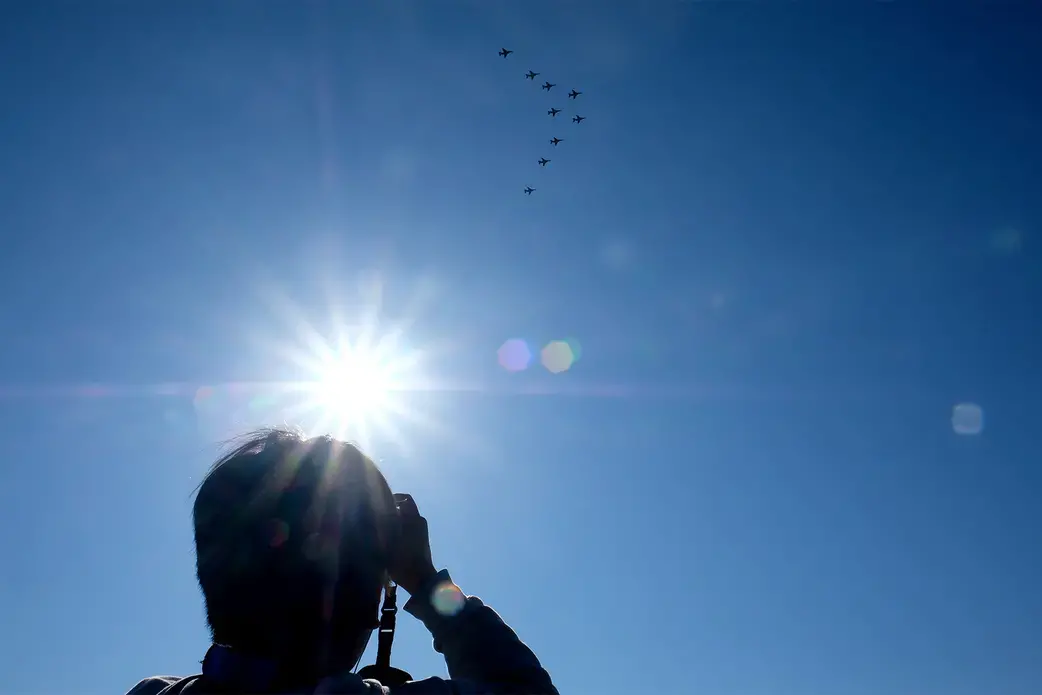 A man captures shots of JASDF planes. Image by Emiko Jozuka. Japan, 2018. 