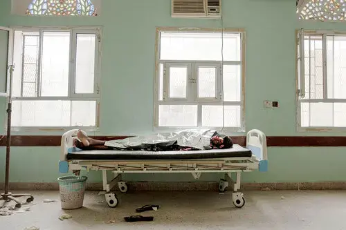 In this July 26, 2019 photo, 22-year-old Dasto Mohammed, a migrant from Ethiopia, lays on a gurney after disembarking from a boat and feeling sick from the sea, at the Ras al-Ara Hospital, Lahj, Yemen. Mohammed left home in Harar, Ethiopia with her younger sister Fadya. The girls spent an entire month traveling before they reached Yemen's Ras al-Ara. Image by Nariman El-Mofty / AP Photo. Yemen, 2019.