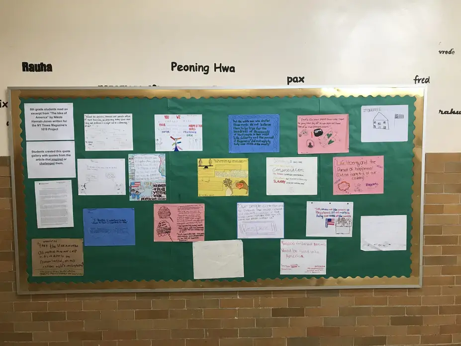 Image of a bulletin board of quotes from The 1619 Project for the hall of their school.