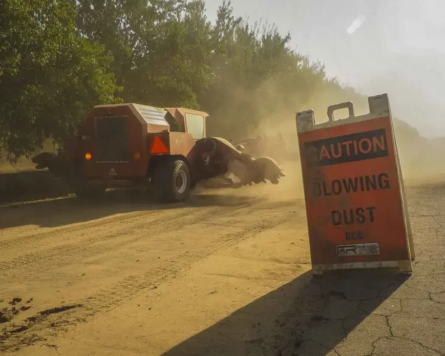 The nuts are then blown and swept into piles. The process kicks up massive clouds of dust and debris. Image by Larry C. Price. California, 2018.