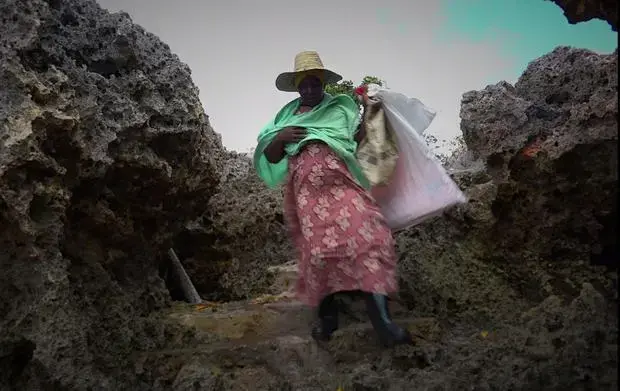 A seaweed farmer carries a life jacket for her boat trip into the deep water. Many women in Zanzibar cannot swim. Image by&nbsp;Haley Joelle Ott. Zanzibar, 2017.