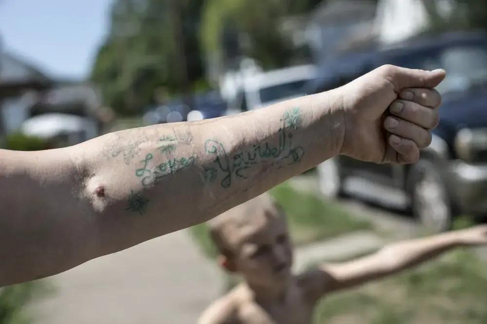 Brittany Cunningham 31, shows off her tattoo which reads, 'Love Yourself' on her left forearm in Nelsonville, Ohio. Image by Wong Maye-E/AP Photo. United States, 2020.