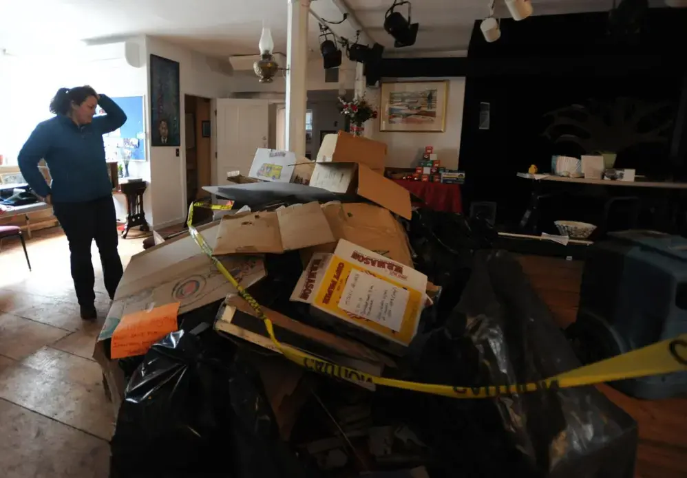 The Rev. Kate Wilkinson surveyed the damage at the Universalist Meetinghouse Church after the 2018 flood. Image by Merrily Cassidy. United States, 2018.