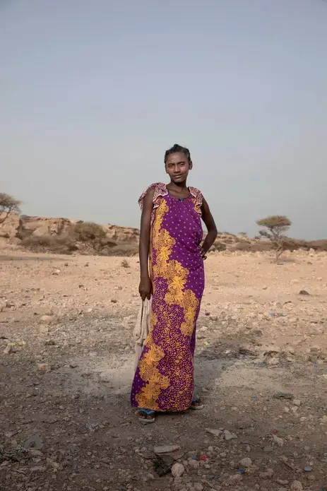 In this July 15, 2019 photo, 15-year old Medres, a migrant from Ethiopia, poses for a portrait, as she and others take shelter on the last stop of their journey before leaving by boat to Yemen in the evening, in Obock, Djibouti. She said she doesn't speak Arabic_ the majority language in the oil-rich Kingdom. She was told that she should be able to learn the language in one month. She could earn as much as 2500 to 3000 riyals, about 700 U.S. dollars. Image by Nariman El-Mofty / AP Photo. Djibouti, 2019.