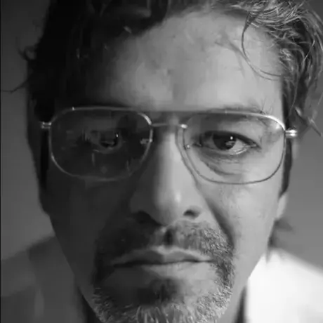 A person wears a shirt and glasses.