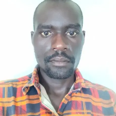 A man with an orange shirt stares into the camera