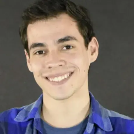 A person with short hair and wears a blue flannel shirt.