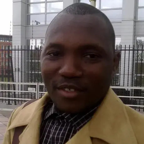 A man wears a brown jacket with a brown shirt.