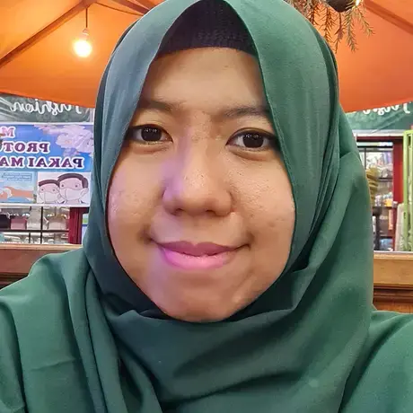 a woman with a green hijab stares into the camera