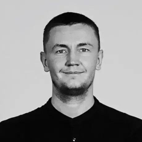 Black and white photo of a man with short dark hair and a dark shirt