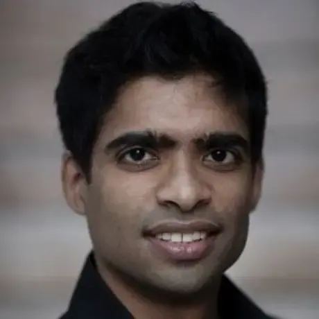 Headshot of a smiling man with short dark hair
