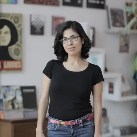 A woman with short black hair wearing a black tshirt