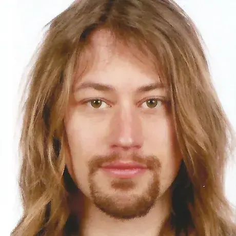 A man with long light-colored hair and facial hair
