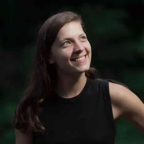 A woman with long dark hair wears a black shirt