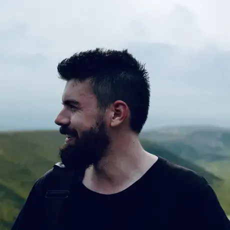 Side profile of Hugh against a mountainous background